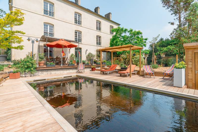 Réalisation d'une piscine bio en Normandie avec une terrasse en bois autour